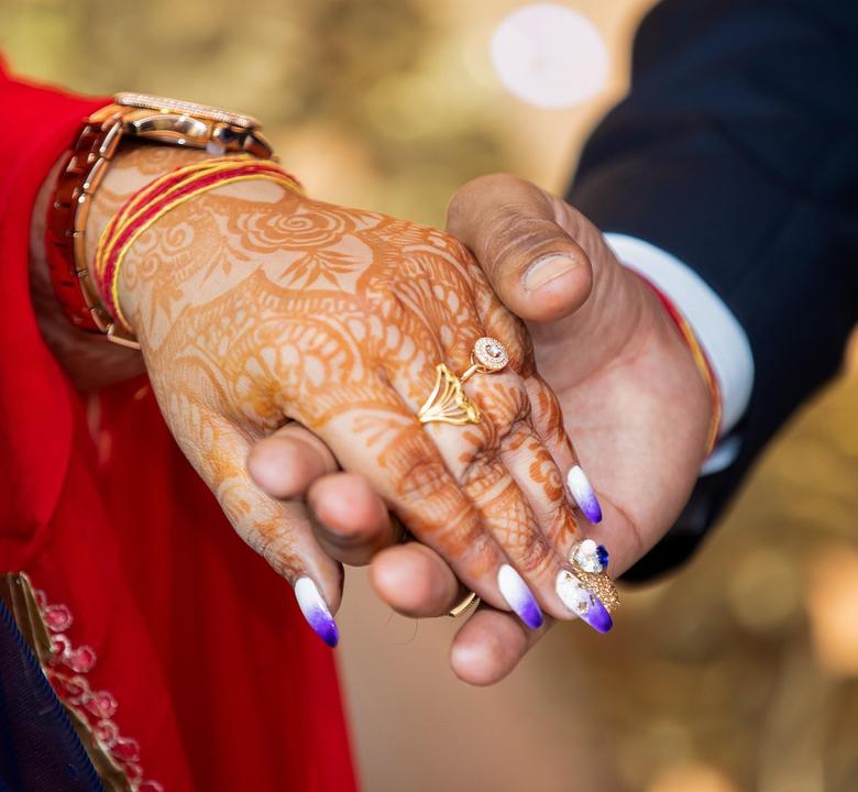 The couple's hands, with a ring